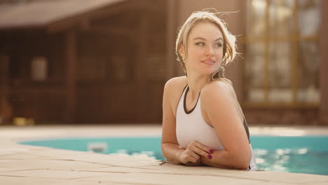happy-young-woman-is-resting-in-warm-thermal-bath-outdoor-joyful-female-visitor-of-modern-spa-complex-and-hotel